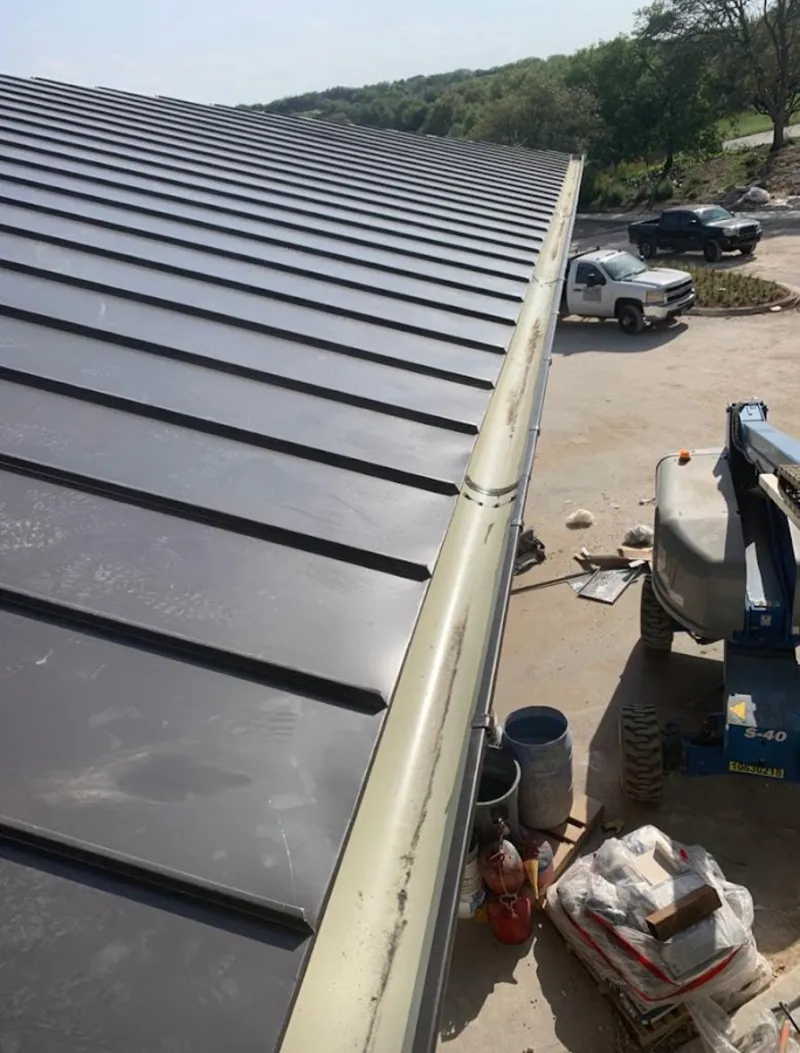 Standing seam panel and gutter detail on a metal roofing jobsite in Alpine
